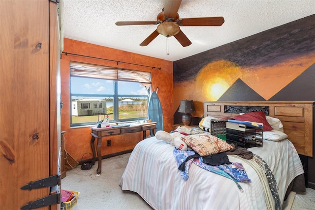 bedroom with light carpet, a textured ceiling, and a ceiling fan