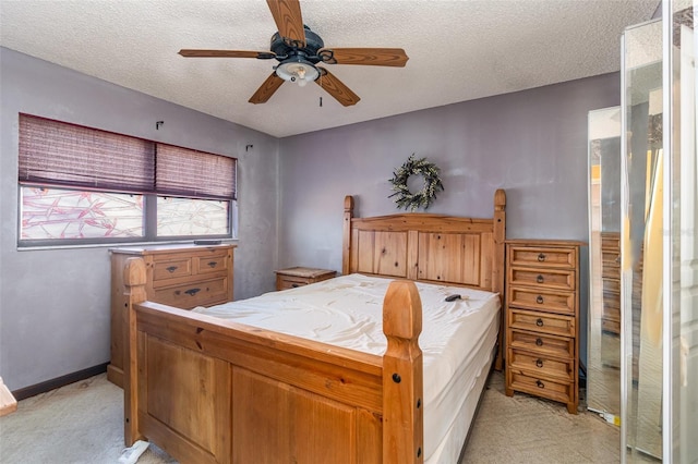 bedroom featuring ceiling fan, a textured ceiling, and light colored carpet