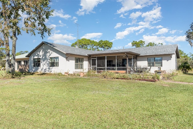 back of property with a yard, a sunroom, and stucco siding