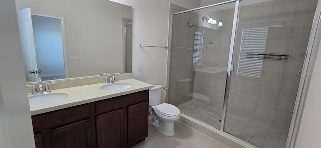 bathroom featuring a stall shower, a sink, toilet, and double vanity