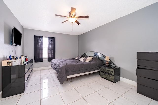 bedroom featuring light tile patterned flooring, baseboards, and ceiling fan