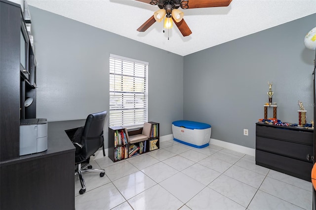 home office with light tile patterned floors, ceiling fan, and baseboards