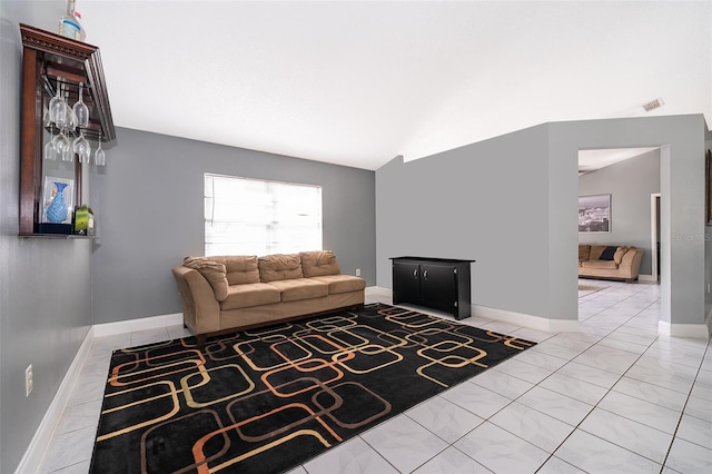 living room with vaulted ceiling, light tile patterned floors, baseboards, and visible vents