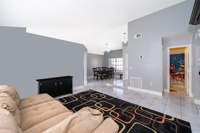 living room with an inviting chandelier, lofted ceiling, baseboards, and visible vents