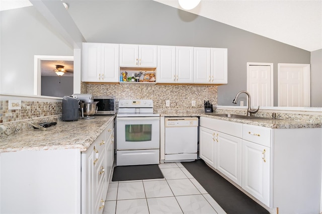 kitchen with white appliances, a peninsula, lofted ceiling, and a sink