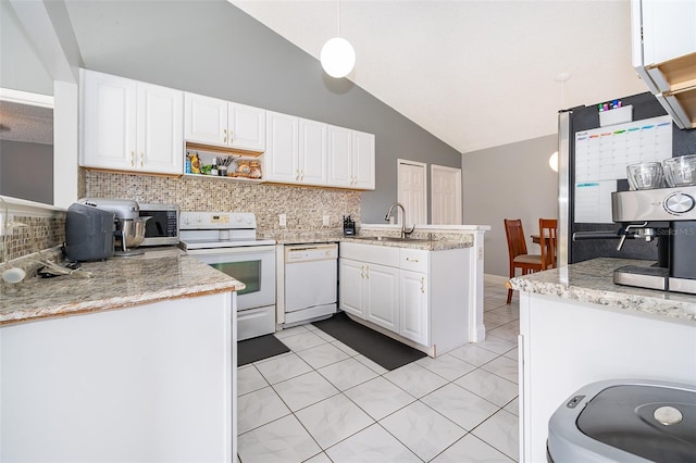 kitchen featuring vaulted ceiling, appliances with stainless steel finishes, a peninsula, white cabinetry, and a sink