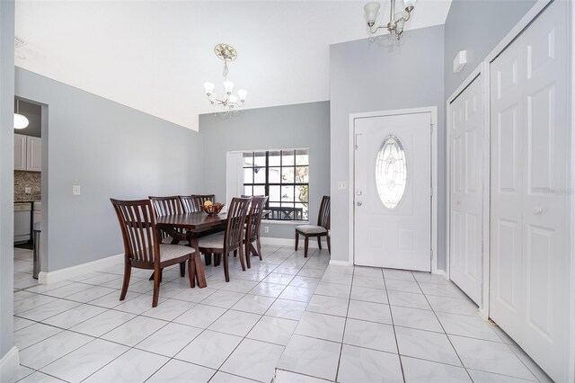 dining space featuring a chandelier, baseboards, and light tile patterned flooring