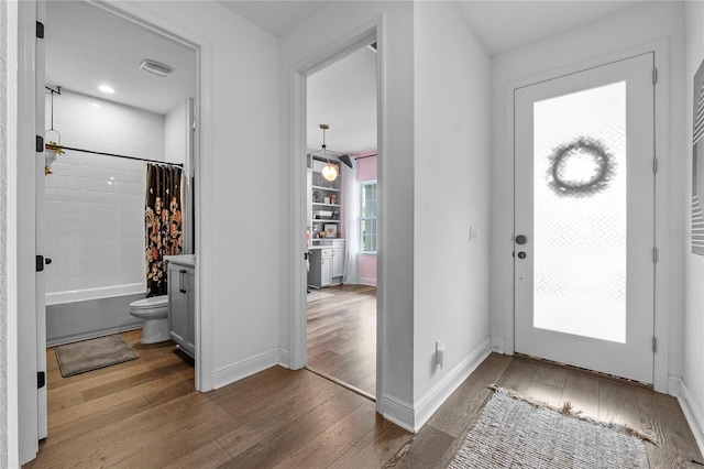 entrance foyer featuring wood-type flooring, visible vents, and baseboards