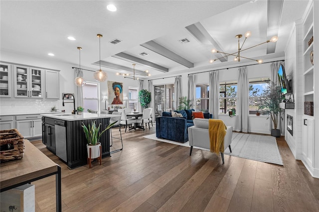 interior space featuring hardwood / wood-style flooring, visible vents, and a notable chandelier