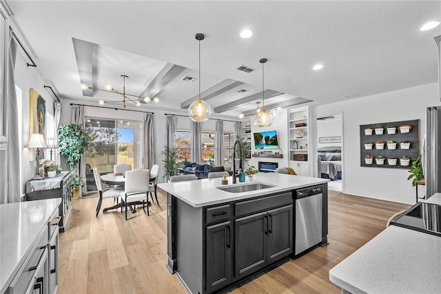 kitchen with dishwasher, light wood finished floors, open floor plan, and a sink