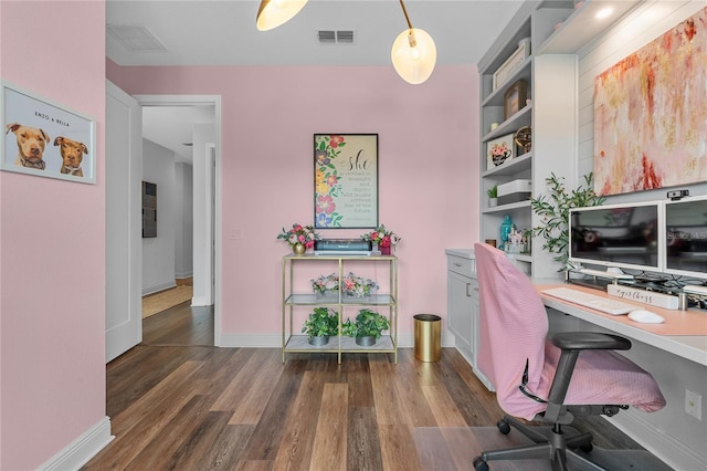 home office featuring wood finished floors, visible vents, and baseboards