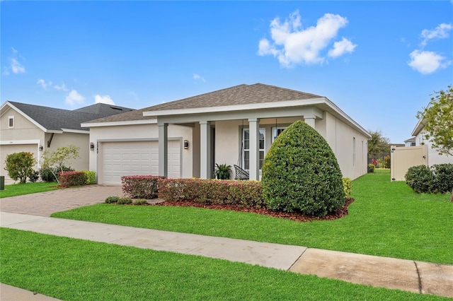 view of front facade featuring an attached garage, a front lawn, decorative driveway, and stucco siding