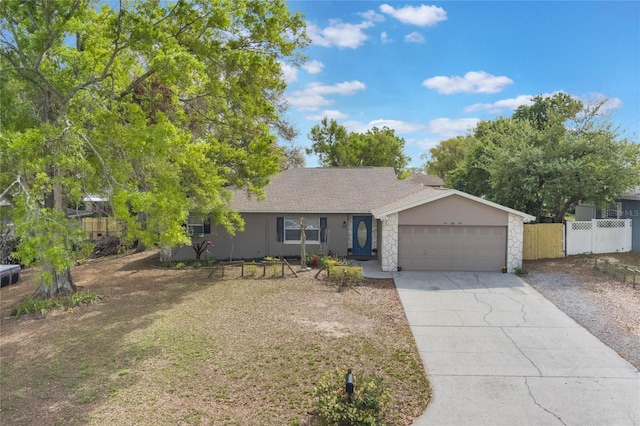 ranch-style house featuring driveway, a shingled roof, stone siding, an attached garage, and fence