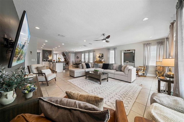 living room with light tile patterned floors, a textured ceiling, and recessed lighting