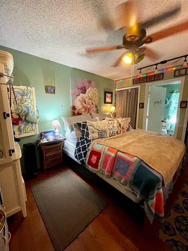bedroom with a ceiling fan, a textured ceiling, and wood finished floors