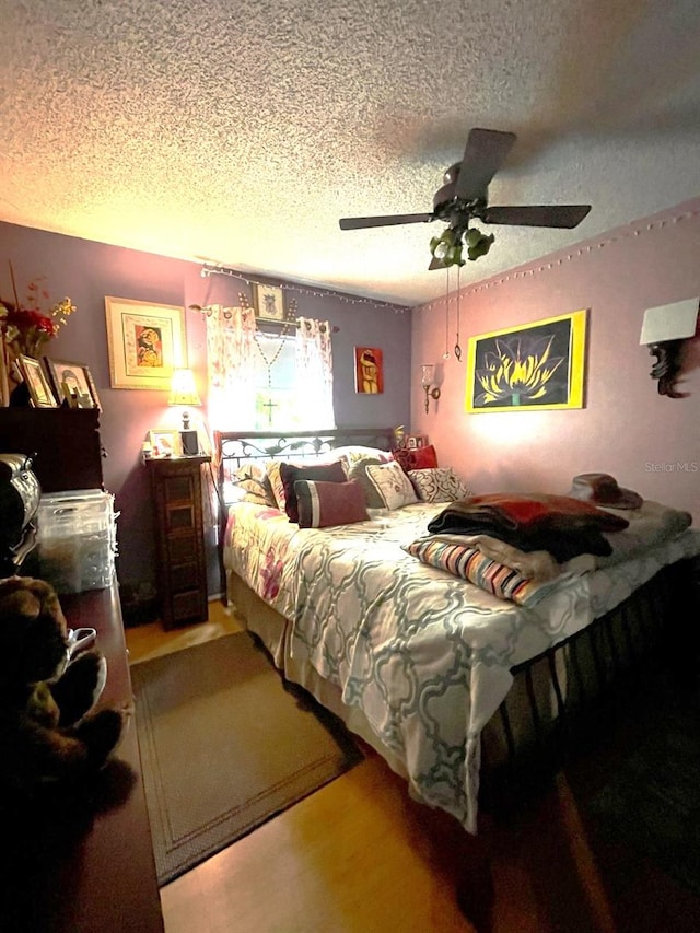bedroom with a textured ceiling and ceiling fan