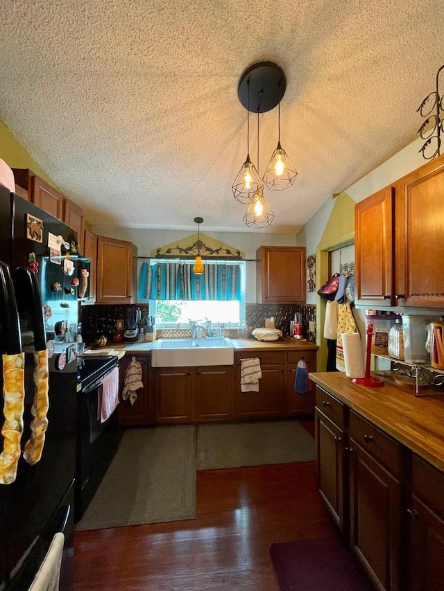 11213 River Grove Dr, Orlando, FL 32817 - kitchen with black appliances, a textured ceiling, a sink, decorative backsplash, and dark wood-style floors