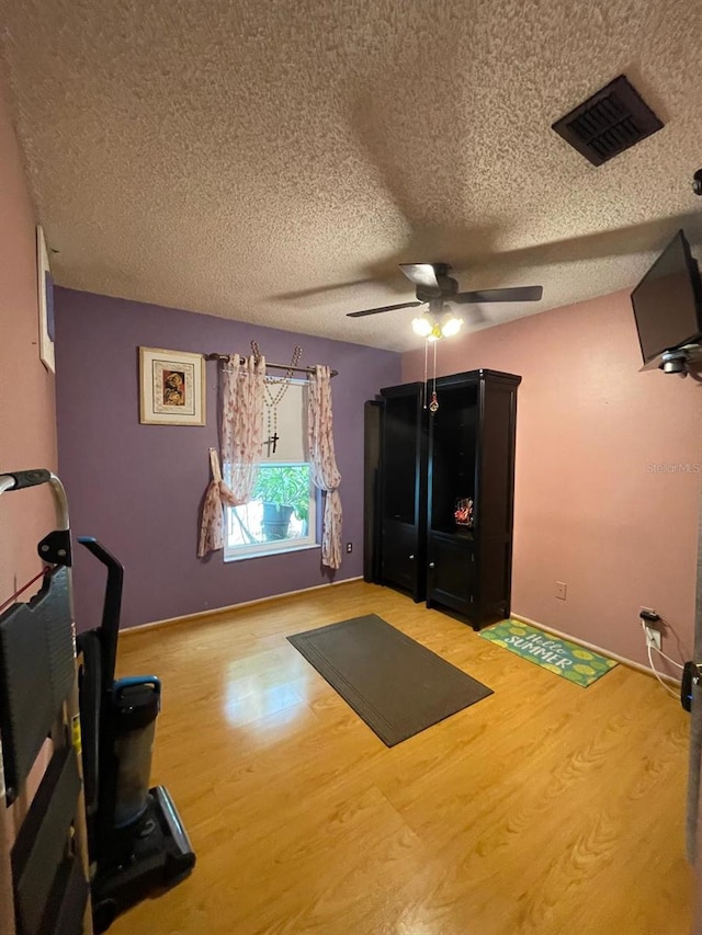 11213 River Grove Dr, Orlando, FL 32817 - exercise room featuring wood finished floors, a ceiling fan, and a textured ceiling