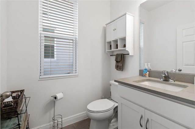 bathroom with vanity, toilet, and baseboards