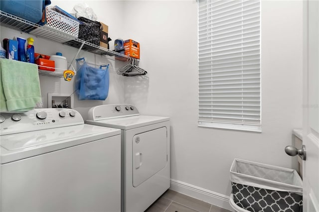 clothes washing area with laundry area, independent washer and dryer, tile patterned flooring, and baseboards