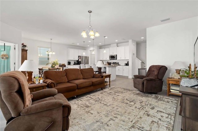 living area featuring light wood-type flooring, an inviting chandelier, visible vents, and recessed lighting