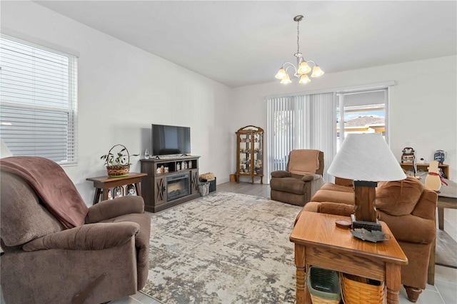 living area featuring a glass covered fireplace and an inviting chandelier