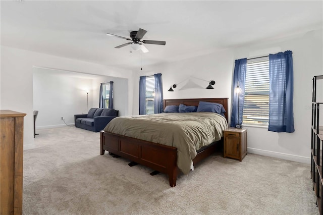 bedroom featuring baseboards, a ceiling fan, and light colored carpet