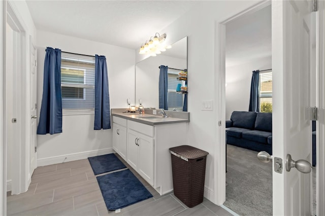 full bathroom with vanity and baseboards