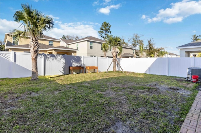 view of yard with a fenced backyard and central AC unit