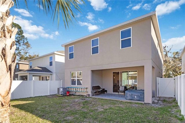 rear view of property with a patio, a yard, a fenced backyard, and stucco siding