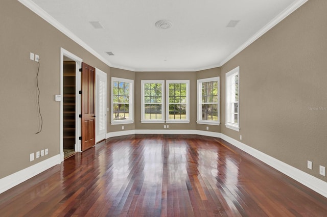 spare room featuring baseboards, crown molding, and hardwood / wood-style floors