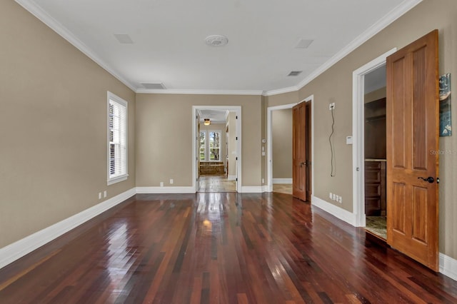 unfurnished room with ornamental molding, hardwood / wood-style floors, visible vents, and baseboards