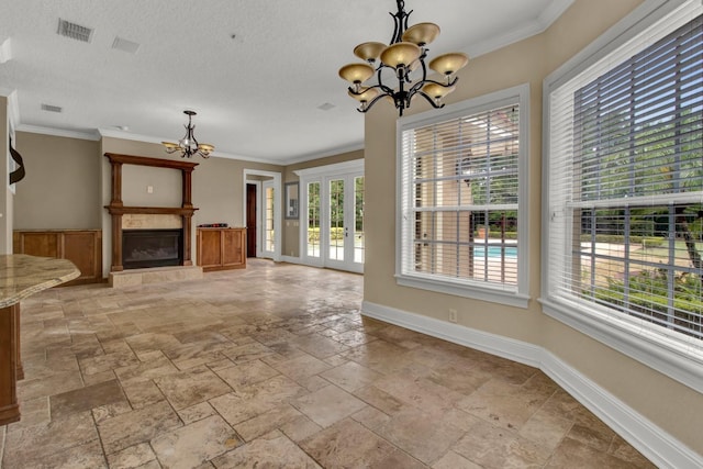 unfurnished living room with a chandelier, crown molding, and baseboards