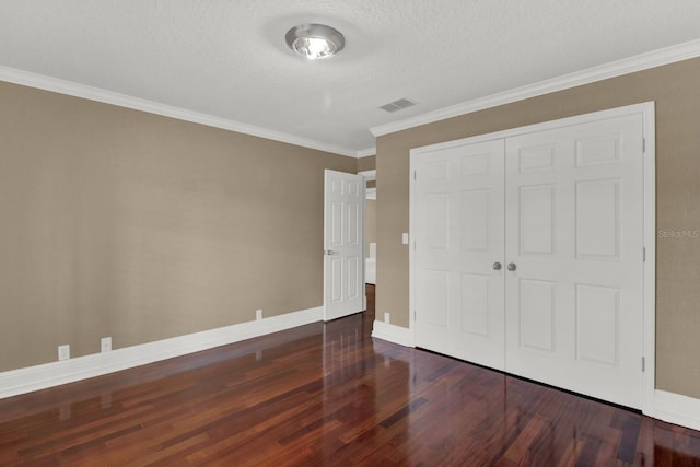 unfurnished bedroom featuring a closet, wood finished floors, visible vents, and baseboards