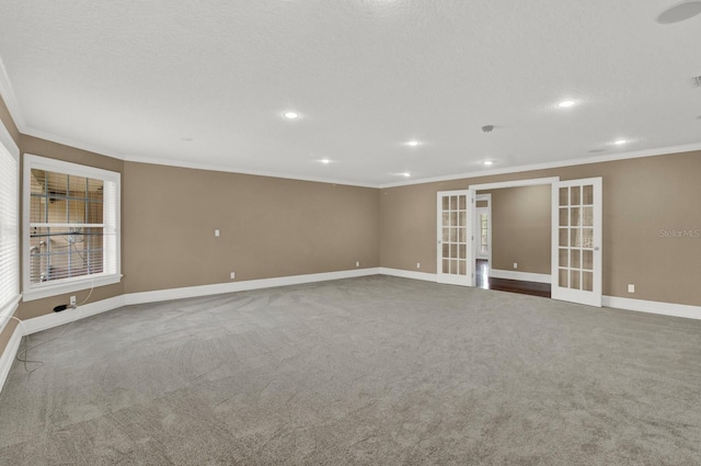 carpeted spare room with a textured ceiling, recessed lighting, baseboards, french doors, and crown molding