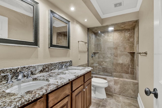 bathroom with toilet, ornamental molding, a sink, and visible vents