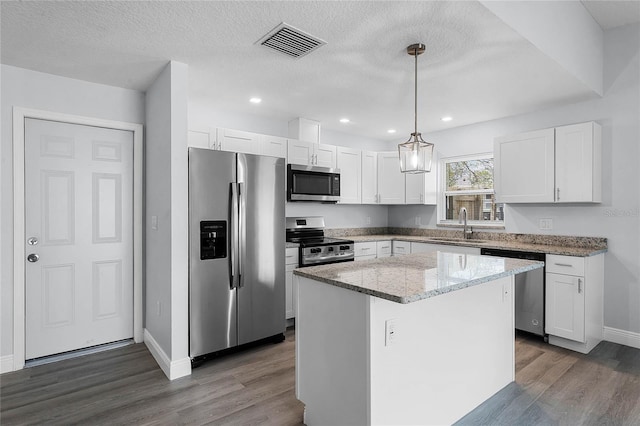 kitchen with stainless steel appliances, a sink, visible vents, white cabinets, and dark wood-style floors