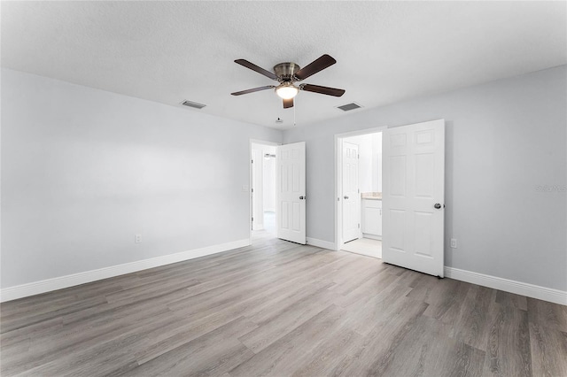 unfurnished bedroom with wood finished floors, visible vents, and baseboards