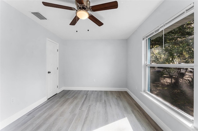 unfurnished room with baseboards, visible vents, and wood finished floors