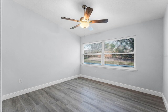 spare room featuring a ceiling fan, baseboards, and wood finished floors