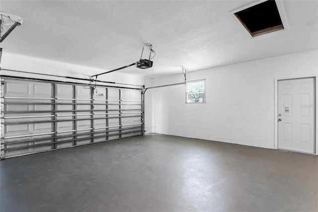 garage featuring concrete block wall and a garage door opener