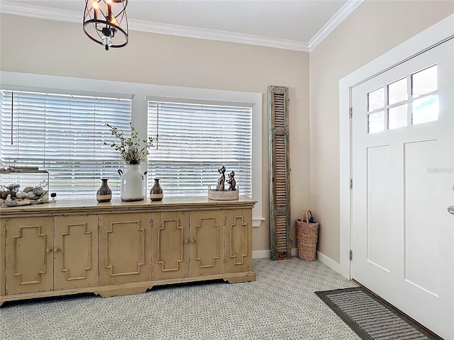 entrance foyer featuring ornamental molding, a notable chandelier, and baseboards