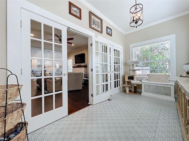 interior space featuring ceiling fan with notable chandelier, ornamental molding, and french doors