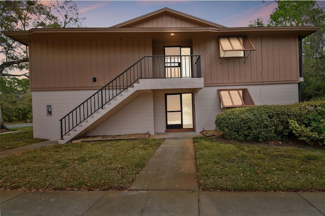 townhome / multi-family property with stairs and a front lawn