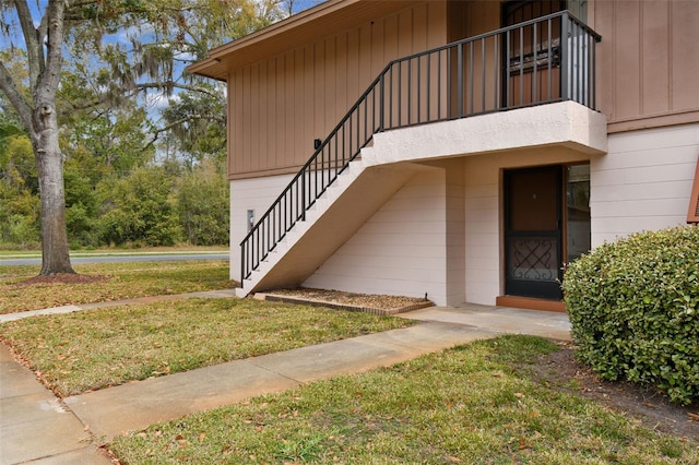 entrance to property with a yard and a balcony