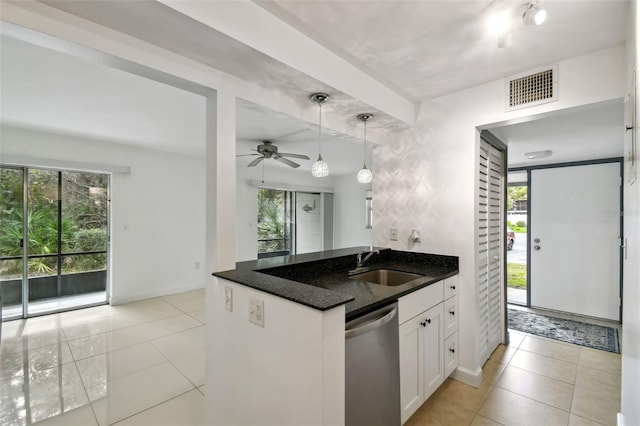 kitchen featuring visible vents, white cabinets, dark stone countertops, a sink, and stainless steel dishwasher