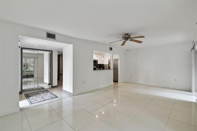 empty room with ceiling fan, visible vents, and light tile patterned flooring
