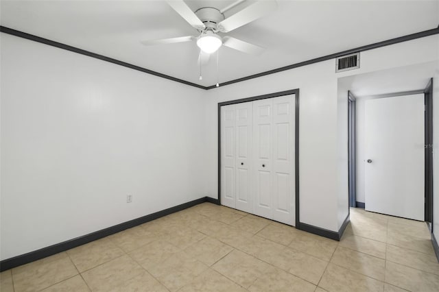 unfurnished bedroom featuring baseboards, visible vents, ornamental molding, a closet, and light tile patterned flooring