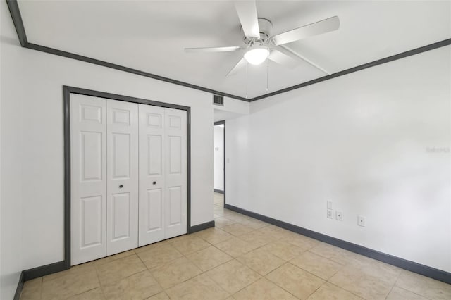 unfurnished bedroom with baseboards, visible vents, a ceiling fan, crown molding, and a closet