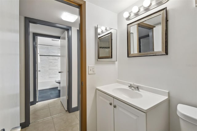bathroom featuring toilet, tile patterned flooring, baseboards, and vanity